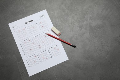 Photo of Student passing exam. Answer sheet, pencil and eraser on gray textured table, flat lay. Space for text