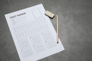 Photo of Answer sheet, pencil and eraser on gray textured table, above view. Student passing exam
