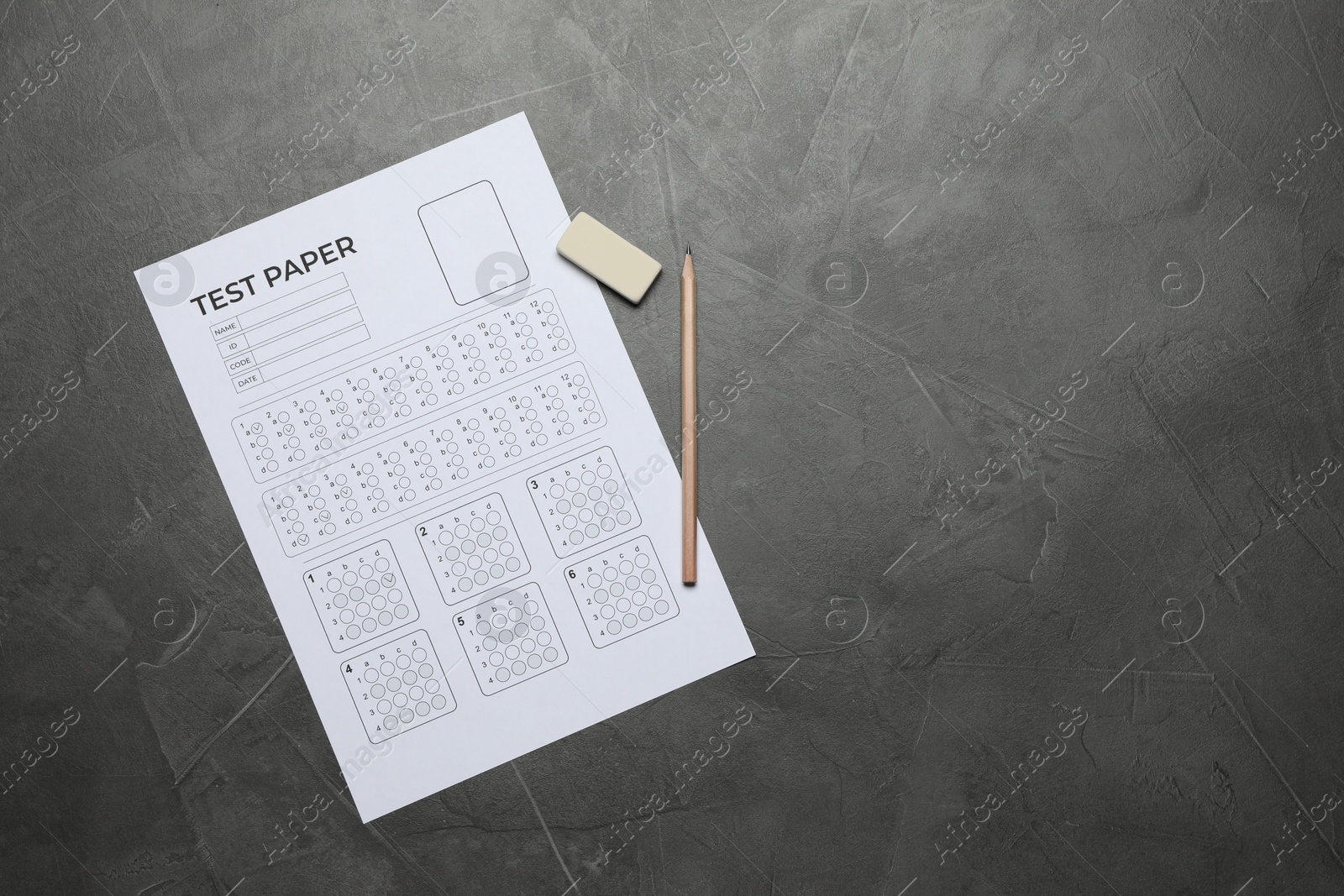 Student passing exam. Answer sheet, pencil and eraser on gray textured table, flat lay. Space for text Photo of Student passing exam. Answer sheet, pencil and eraser on gray textured table, flat lay. Space for text