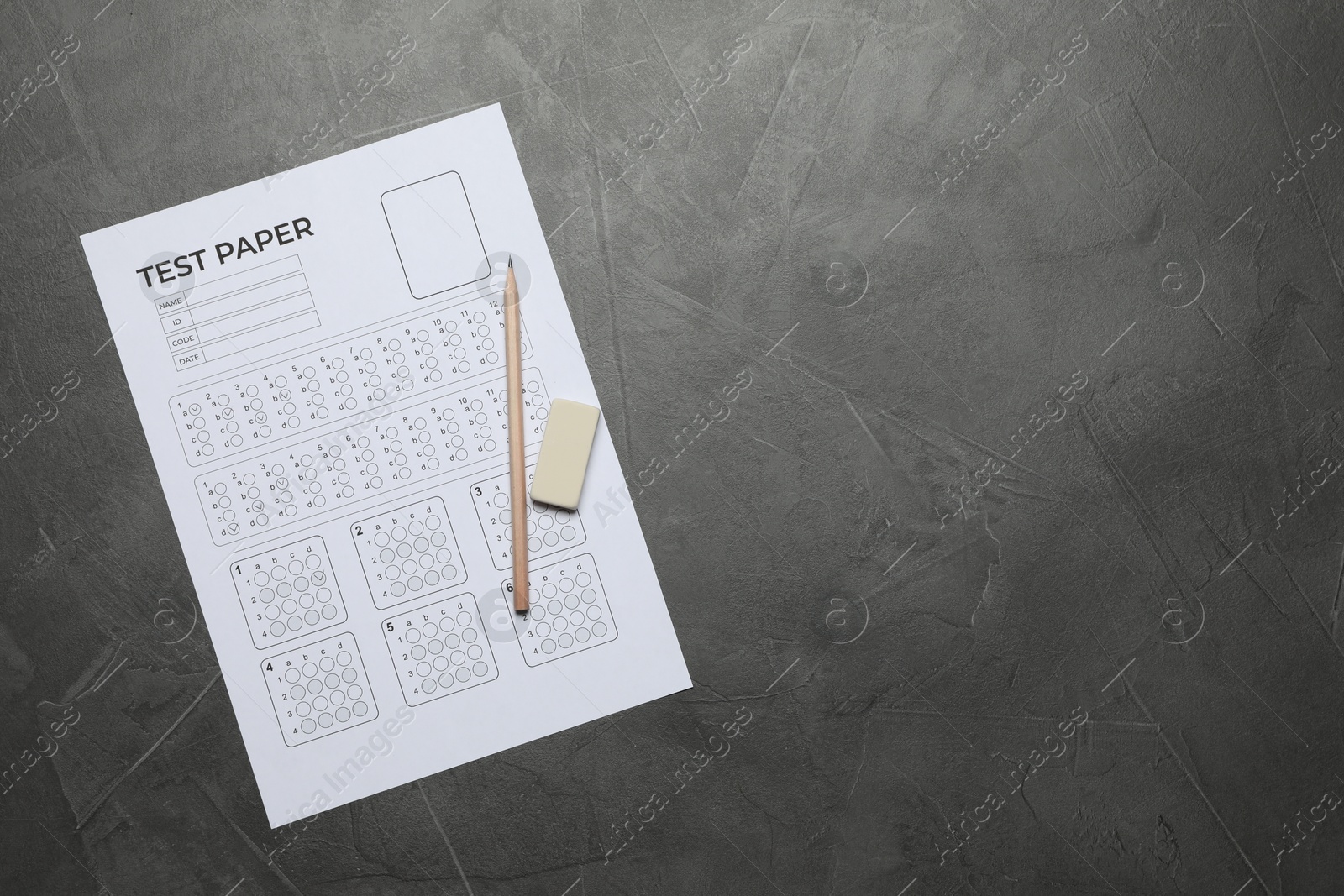 Student passing exam. Answer sheet, pencil and eraser on gray textured table, flat lay. Space for text Photo of Student passing exam. Answer sheet, pencil and eraser on gray textured table, flat lay. Space for text