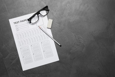 Photo of Student passing exam. Answer sheet, glasses, pencil and eraser on gray textured table, flat lay. Space for text