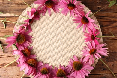 Photo of Frame of beautiful Echinacea flowers on wooden table, flat lay. Space for text
