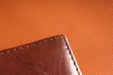 Photo of Brown natural leather with seam on color surface, closeup. Space for text