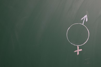 Photo of Sex education. Gender symbols drawn on green chalkboard, space for text
