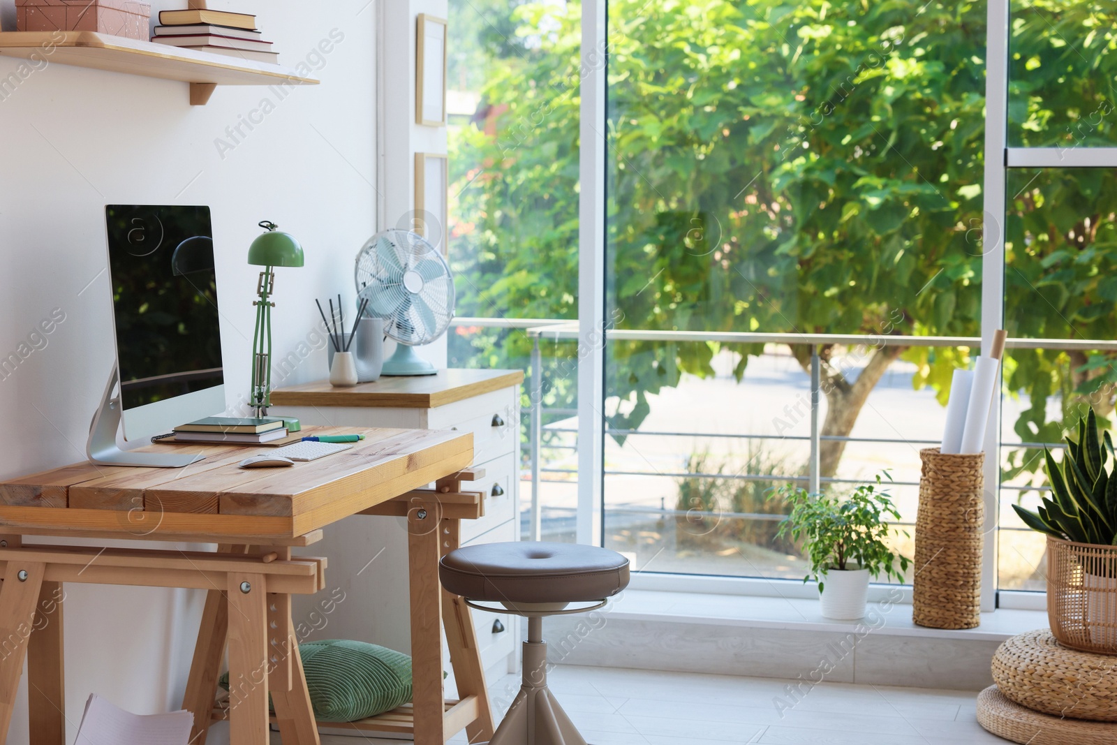 Photo of Home workspace. Modern computer and stationery on wooden desk near window indoors