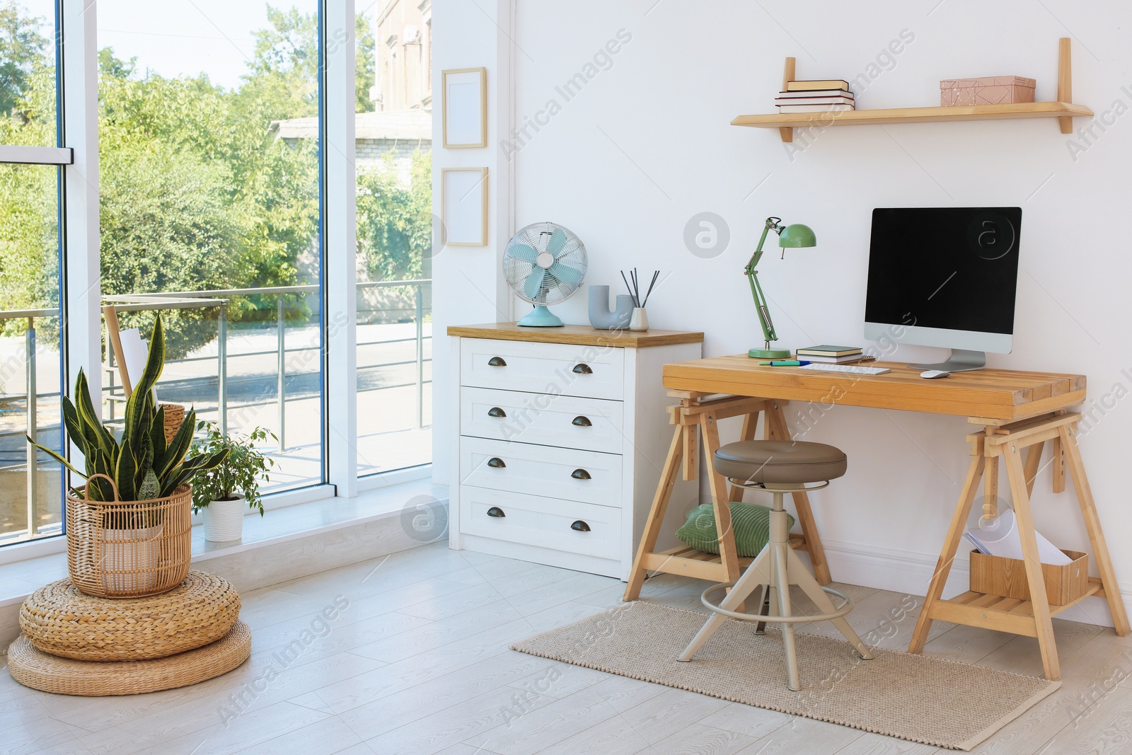 Photo of Home workspace. Modern computer and stationery on wooden desk near window indoors