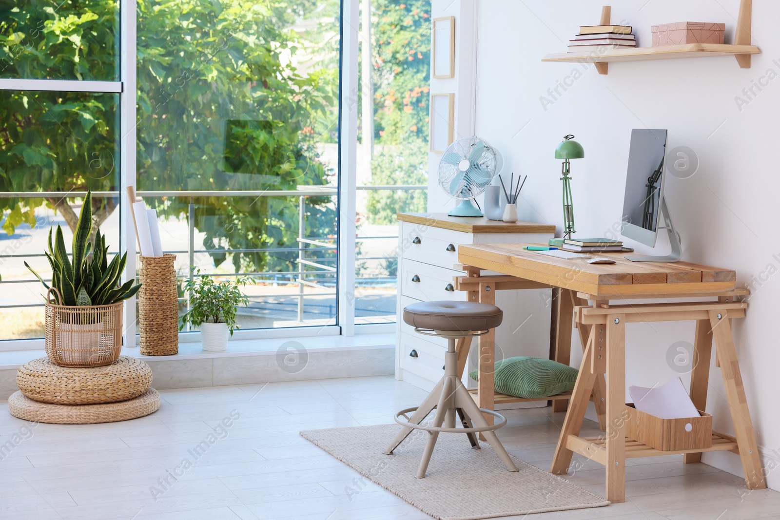 Photo of Home workspace. Modern computer and stationery on wooden desk near window indoors