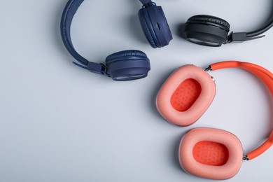 Photo of Different stylish headphones on light grey background, flat lay. Space for text