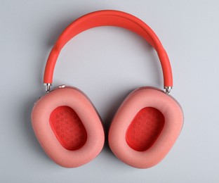 Photo of Pair of stylish pink headphones on light grey background, top view