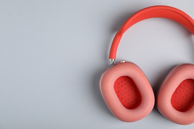 Photo of Pair of stylish pink headphones on light grey background, top view. Space for text