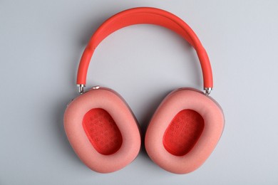 Photo of Pair of stylish pink headphones on light grey background, top view