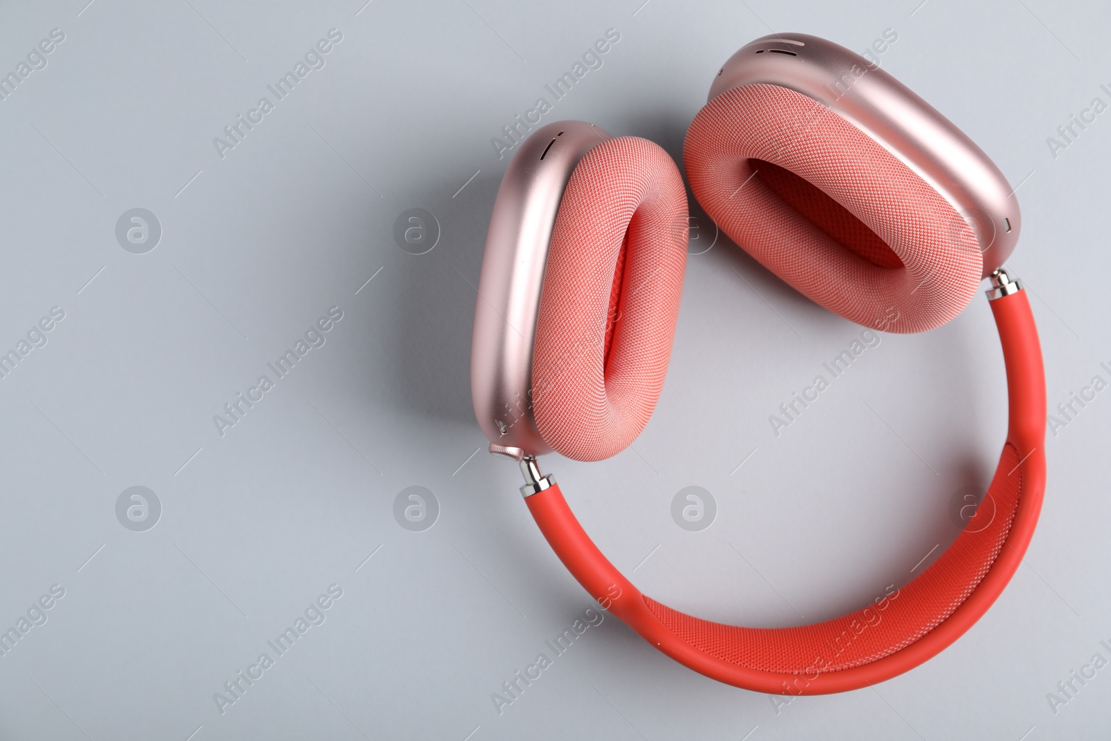 Pair of stylish pink headphones on light grey background, top view. Space for text Photo of Pair of stylish pink headphones on light grey background, top view. Space for text