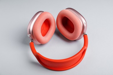 Photo of Pair of stylish pink headphones on light grey background