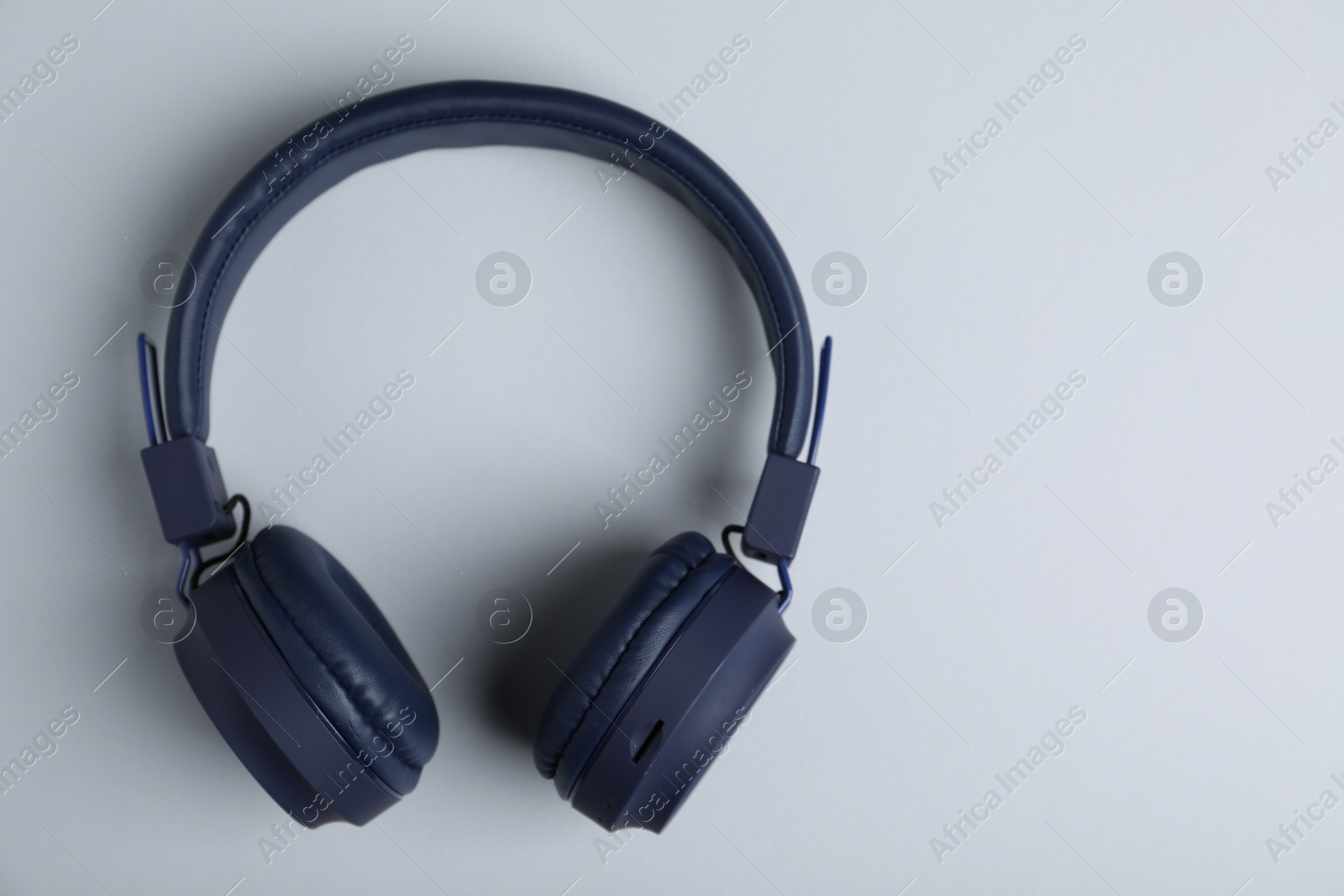 Pair of stylish blue headphones on light grey background, top view. Space for text Photo of Pair of stylish blue headphones on light grey background, top view. Space for text