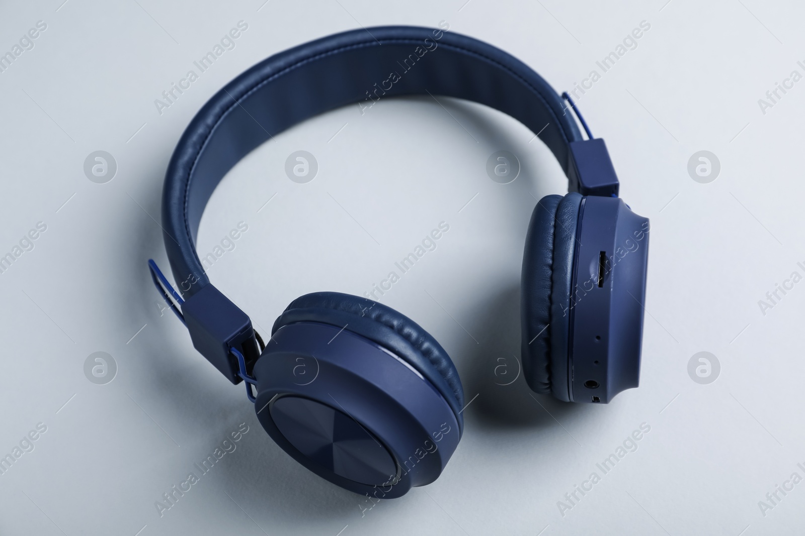 Pair of stylish blue headphones on light grey background, above view Photo of Pair of stylish blue headphones on light grey background, above view