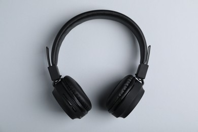Photo of Pair of stylish black headphones on light grey background, top view