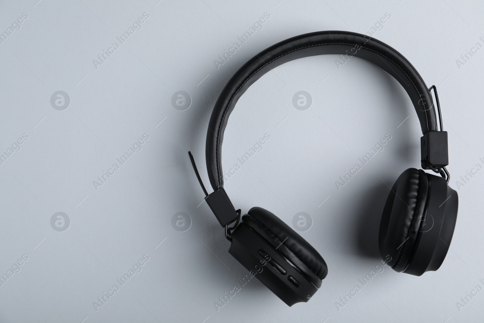 Pair of stylish black headphones on light grey background, top view. Space for text Photo of Pair of stylish black headphones on light grey background, top view. Space for text
