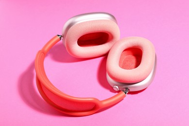 Photo of Pair of stylish headphones on pink background