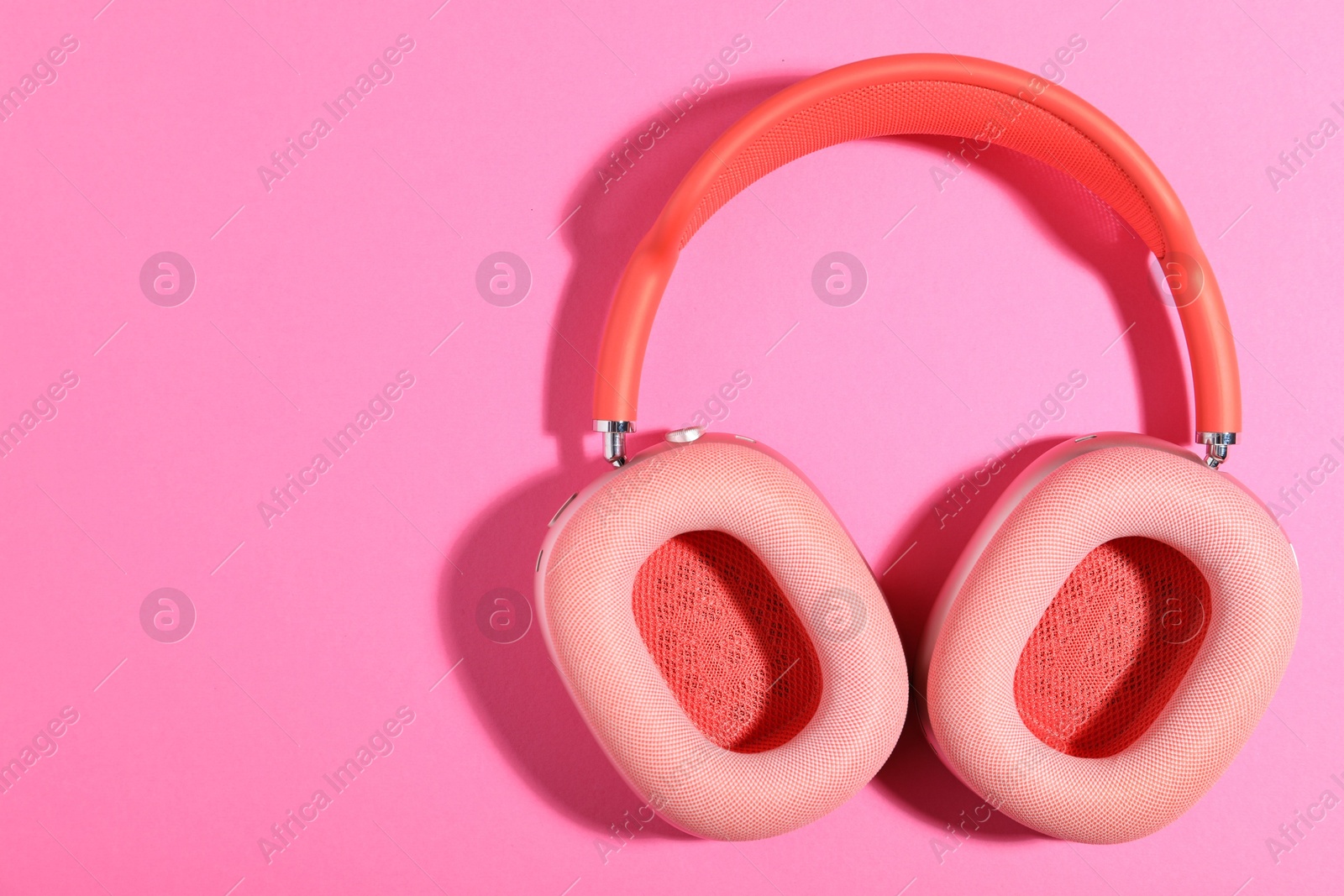 Pair of stylish headphones on pink background, top view. Space for text Photo of Pair of stylish headphones on pink background, top view. Space for text