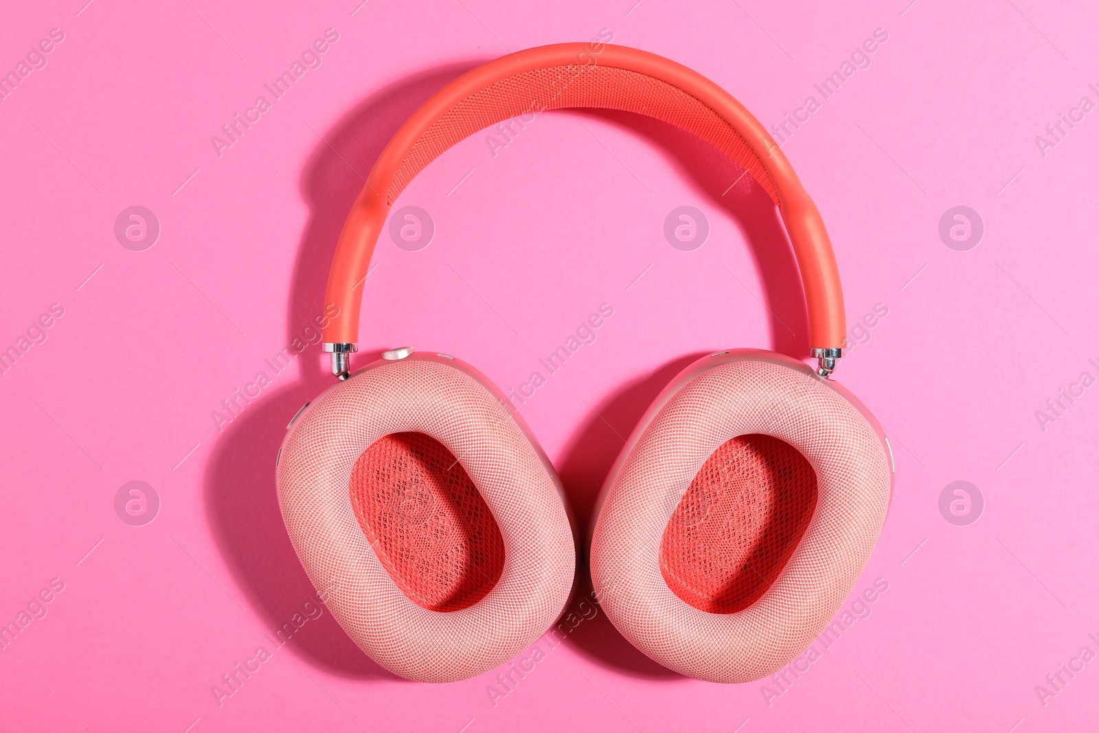 Pair of stylish headphones on pink background, top view Photo of Pair of stylish headphones on pink background, top view