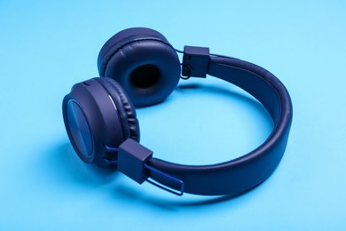 Photo of Pair of stylish headphones on light blue background