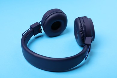 Photo of Pair of stylish headphones on light blue background