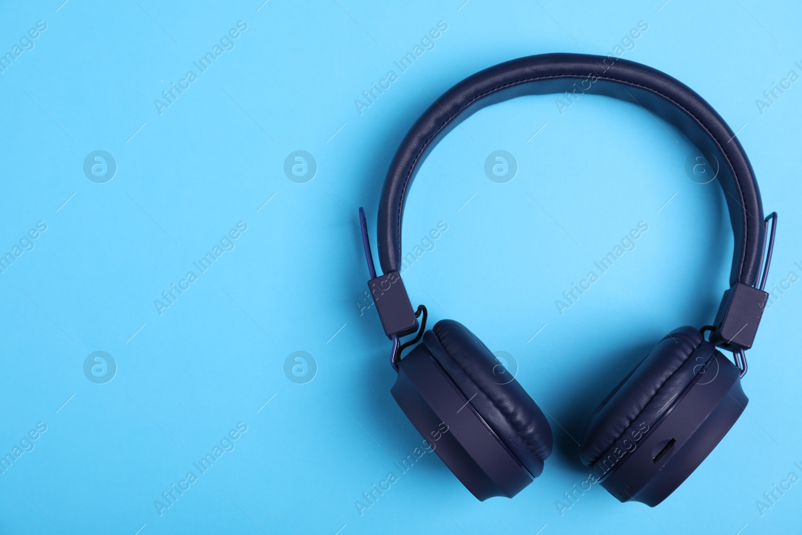 Pair of stylish headphones on light blue background, top view. Space for text Photo of Pair of stylish headphones on light blue background, top view. Space for text