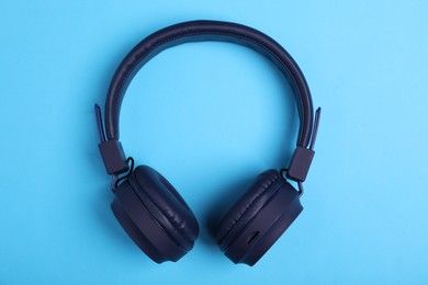 Photo of Pair of stylish headphones on light blue background, top view