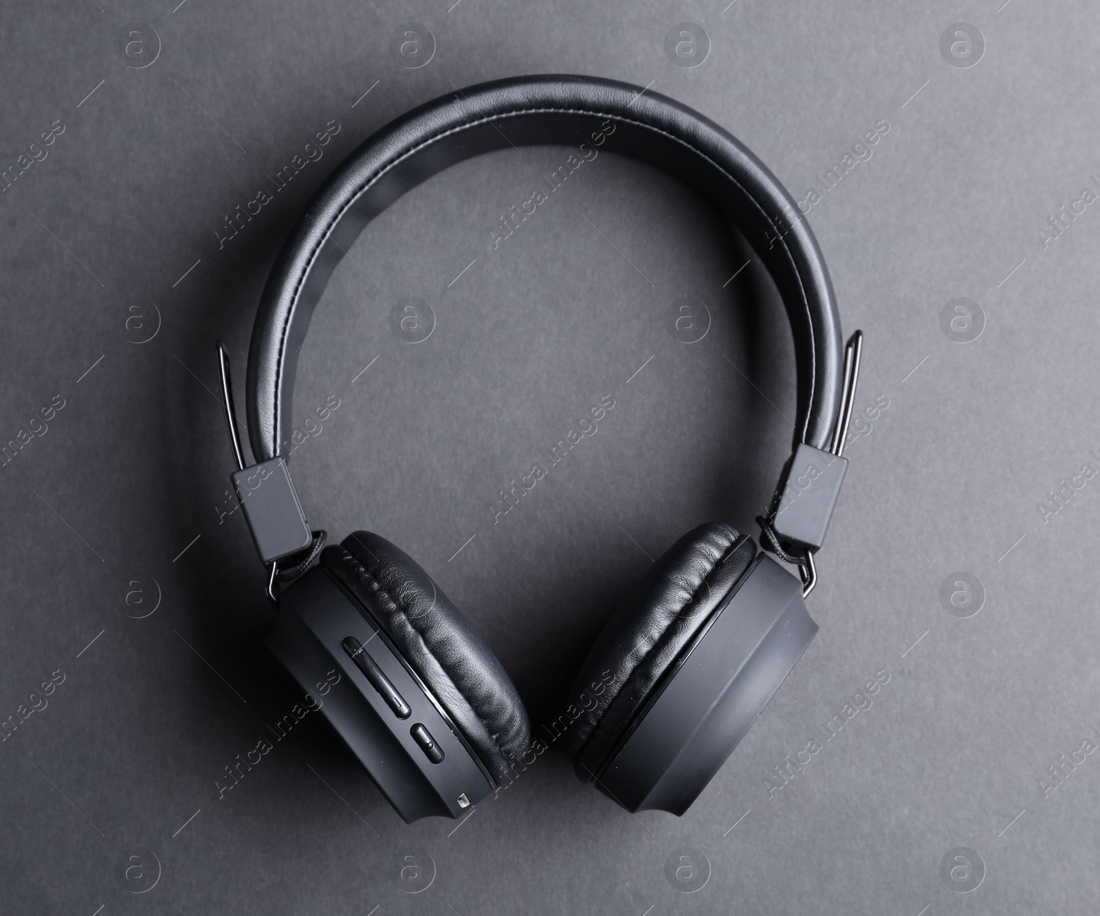 Pair of stylish headphones on black background, top view Photo of Pair of stylish headphones on black background, top view
