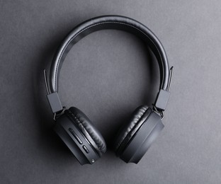 Photo of Pair of stylish headphones on black background, top view