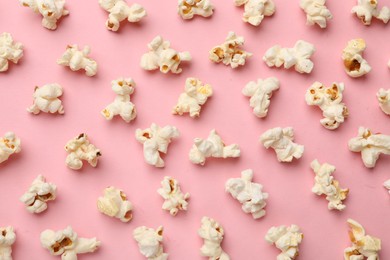 Photo of Tasty popcorn on pink background, flat lay