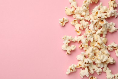 Photo of Tasty popcorn on pink background, flat lay. Space for text