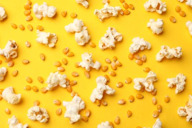 Photo of Tasty popcorn and dry kernels on yellow background, flat lay