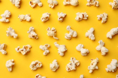 Photo of Tasty popcorn on yellow background, flat lay