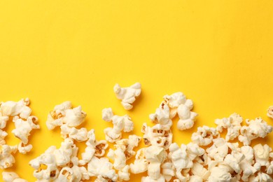 Photo of Tasty popcorn on yellow background, flat lay. Space for text