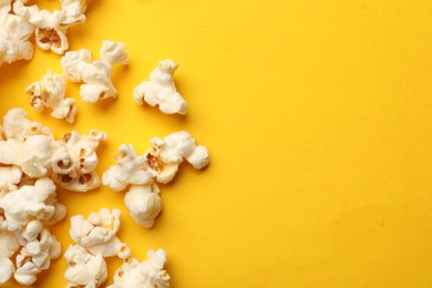 Photo of Tasty popcorn on yellow background, flat lay. Space for text