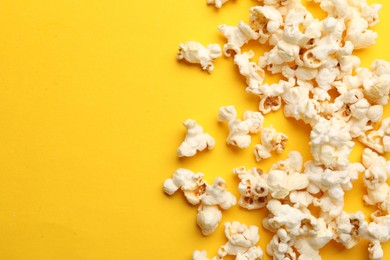 Photo of Tasty popcorn on yellow background, flat lay. Space for text