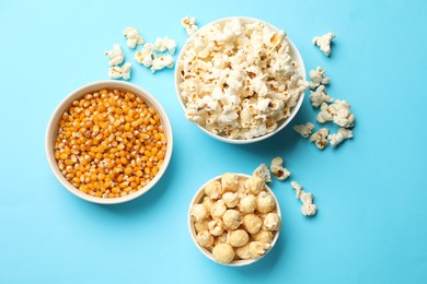 Photo of Tasty popcorn and dry kernels in bowls on light blue background, flat lay