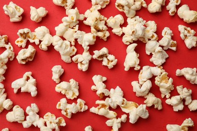 Photo of Tasty popcorn on red background, flat lay
