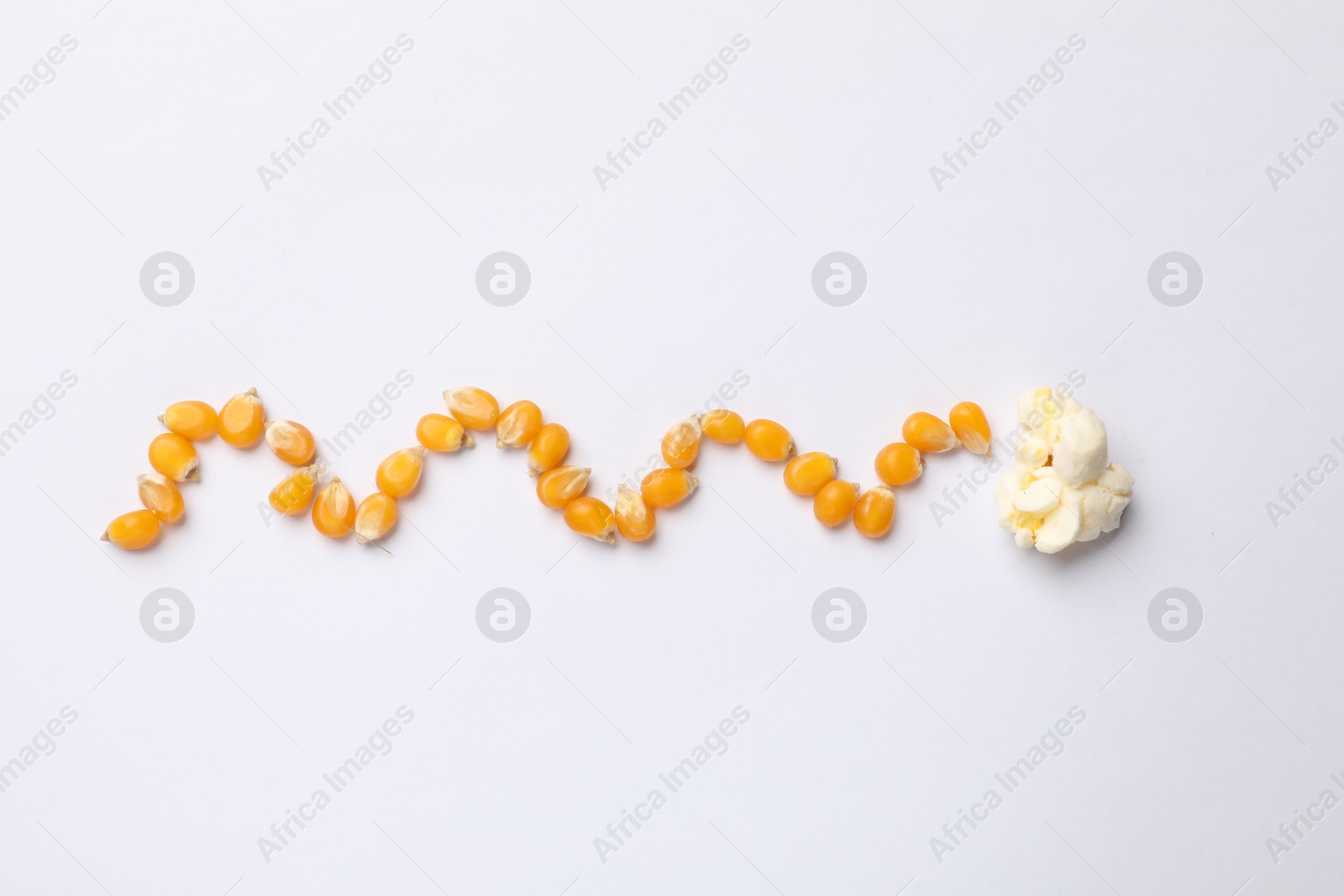 Tasty popcorn and dry kernels on white background, flat lay Photo of Tasty popcorn and dry kernels on white background, flat lay
