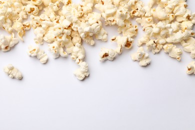Photo of Tasty popcorn on white background, flat lay. Space for text
