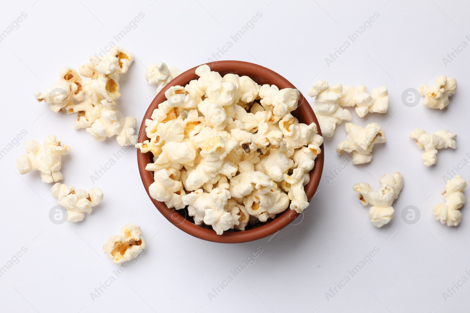 Tasty popcorn in bowl on white background, flat lay Photo of Tasty popcorn in bowl on white background, flat lay