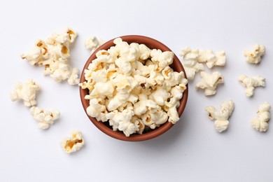 Photo of Tasty popcorn in bowl on white background, flat lay