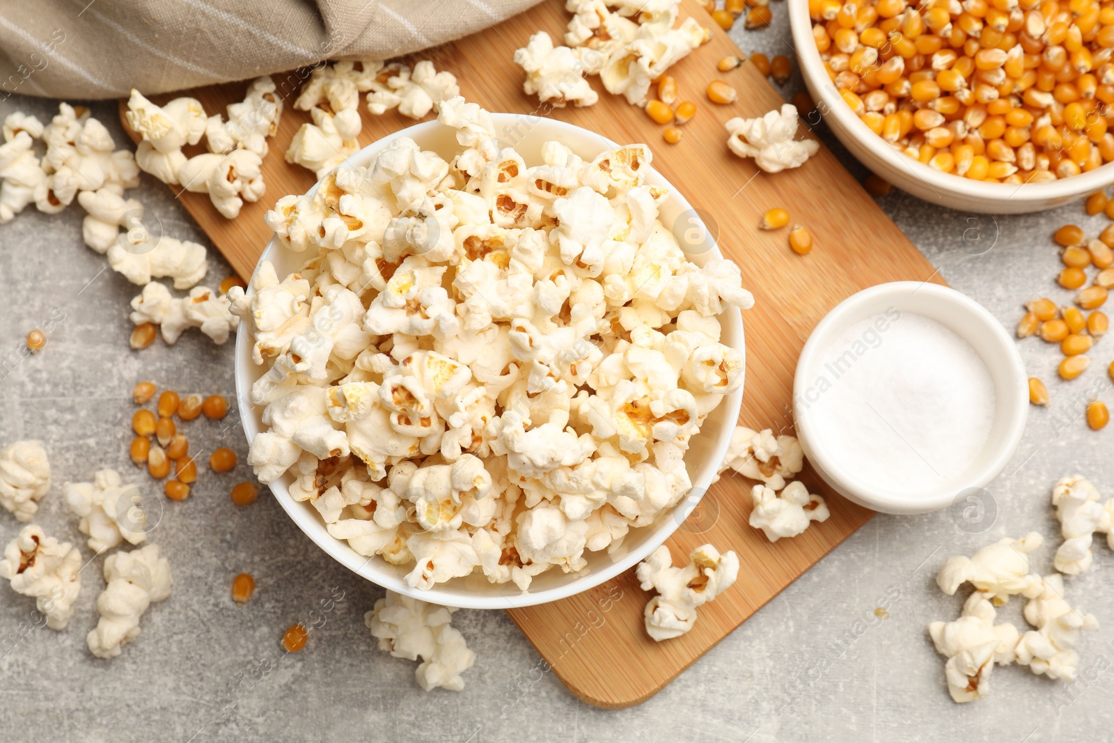 Tasty popcorn and corn kernels on light grey table, flat lay Photo of Tasty popcorn and corn kernels on light grey table, flat lay