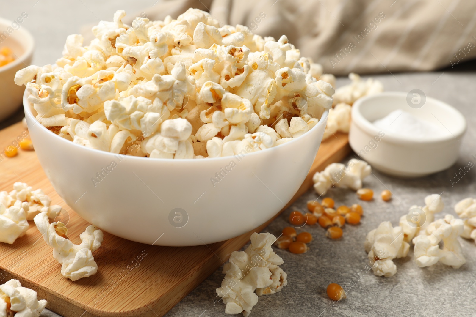Tasty popcorn and corn kernels on light grey table, closeup Photo of Tasty popcorn and corn kernels on light grey table, closeup