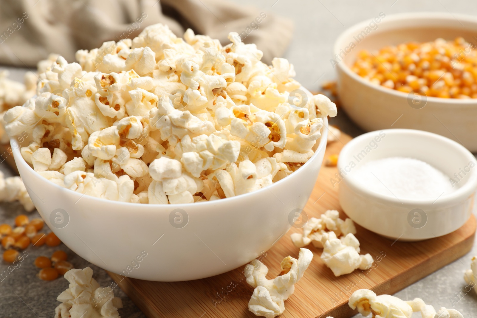 Tasty popcorn and corn kernels on light grey table, closeup Photo of Tasty popcorn and corn kernels on light grey table, closeup