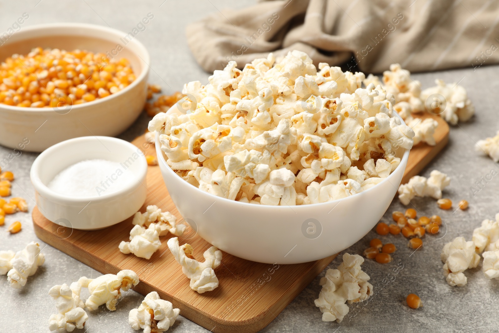 Tasty popcorn and corn kernels on light grey table, closeup Photo of Tasty popcorn and corn kernels on light grey table, closeup