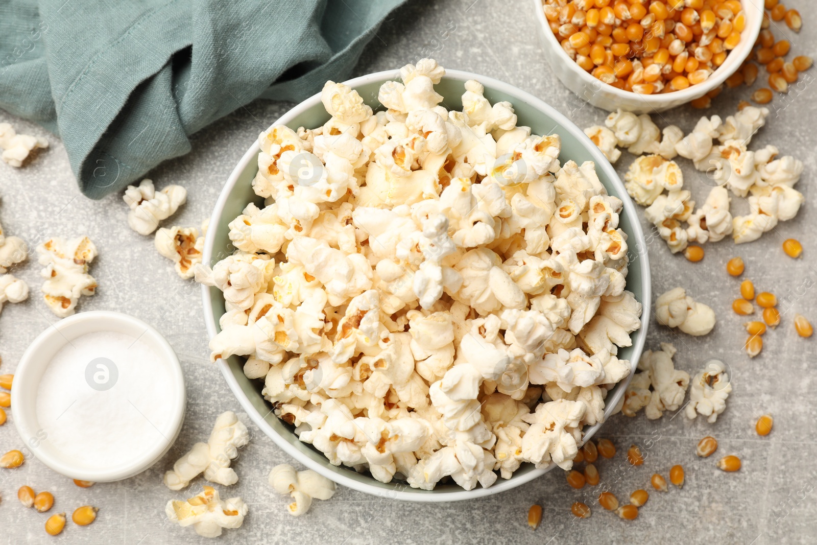 Tasty popcorn and corn kernels on light grey table, flat lay Photo of Tasty popcorn and corn kernels on light grey table, flat lay
