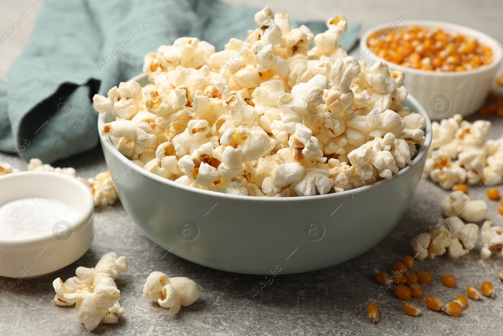 Tasty popcorn and corn kernels on light grey table, closeup Photo of Tasty popcorn and corn kernels on light grey table, closeup