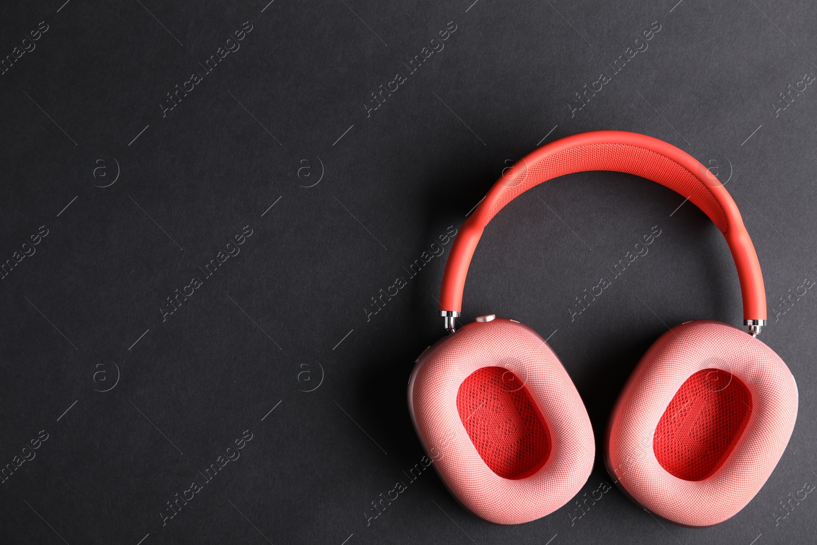 Pair of stylish pink headphones on black background, top view. Space for text Photo of Pair of stylish pink headphones on black background, top view. Space for text